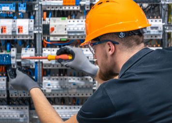 MEP maintenance technician inspecting electrical panel in Deira Dubai