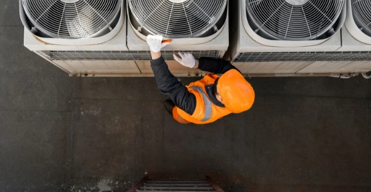 HVAC technician servicing rooftop air conditioning system in Dubai